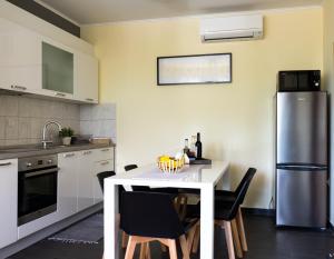 a kitchen with a table with chairs and a refrigerator at Apartment Rose in Korčula