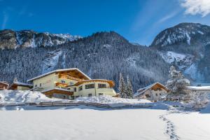 ein Hotel in den Bergen im Schnee in der Unterkunft Pension Rosenhügel in Neustift im Stubaital