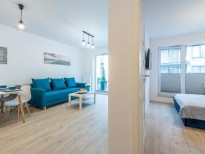 a living room with a blue couch and a table at Bodnar Apartamenty Nadmorskie Tarasy Port in Kołobrzeg +94 photos