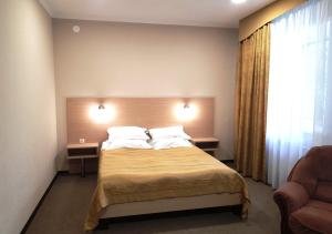 a bedroom with a bed with two pillows and a window at Vizit Hotel in Perm