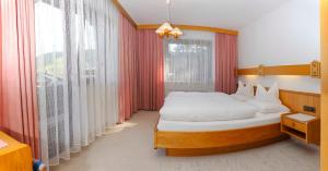 a bedroom with a bed and a large window at Landhaus Haid in Seefeld in Tirol