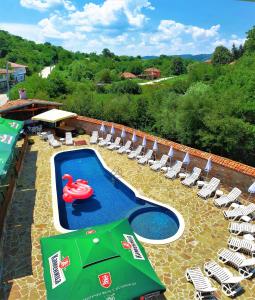 - une piscine avec des chaises et un cygne rouge dans l'établissement Yakovtsi Inn, à Yakovtsi
