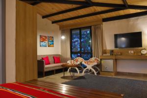 een slaapkamer met een woonkamer met een tv en een bank bij Hotel North House - Best Boutique Hotel in Haldwani in Haldwani