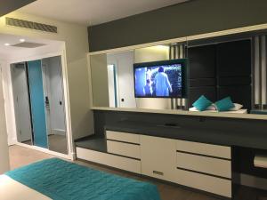 a bedroom with a tv and a large mirror at Oyster Boutique Hotel in Side