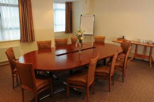 una sala de conferencias con mesa de madera y sillas en Sefton Express Hotel en Ballasalla