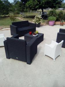 a group of wicker chairs and tables on a patio at la dabinerie in Pruniers