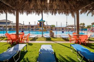 a pool with chairs and tables and a swimming pool at The Dream Compound- by Biankini in Kalia