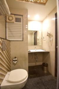 a bathroom with a toilet and a sink at I V Sanctum Hotel in Bengaluru
