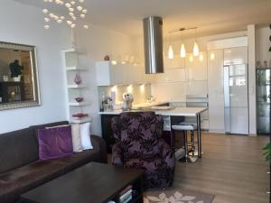 a kitchen and living room with a couch and a table at Modern apt, parking in garage and walk to town in Bratislava