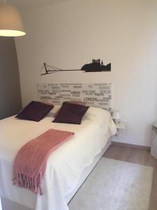 a bedroom with a large white bed with a wall at Modern apt, parking in garage and walk to town in Bratislava