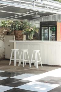 a couple of white stools in front of a counter at Olive Manor Guest House in Newcastle