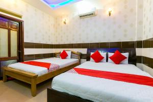 胡志明市的住宿－OYO 261 Binh Dung Hotel，一间卧室配有两张带红色枕头的床