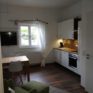 a small kitchen with a table and a window at Ferienwohnung WohlfühlEckerl in Tittmoning