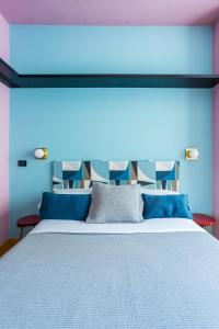 ミラノにあるLovely Studio with Terrace in the heart of Milanの青い壁のベッドルーム1室