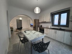 eine Küche mit einem Tisch und Stühlen im Zimmer in der Unterkunft Villa Therme Athena in Emporio