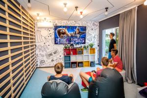 a group of people sitting in a room watching a television at Valamar Camping Ježevac in Krk