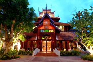 una gran casa de madera con escaleras que conducen a ella en The Rim Chiang Mai, en Chiang Mai