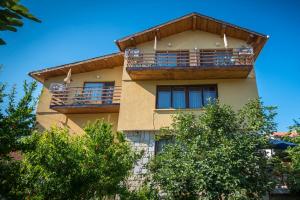 a building with a balcony with trees in front of it at Guest House Sun in Kranevo