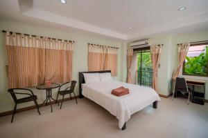 a bedroom with a bed and a table and chairs at Banlanna Hotel Lampang in Lampang
