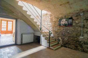 a staircase in a room with a stone wall at Can LLorens in Llagostera
