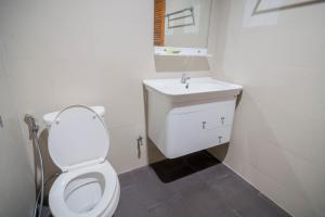 a bathroom with a white toilet and a sink at Banlanna Hotel Lampang in Lampang