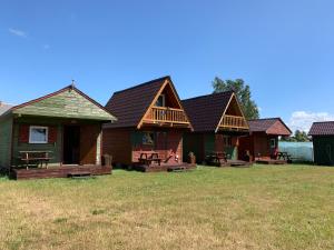 a row of houses with wooden in a field at Osrodek Nadmorski Osieki in Łazy