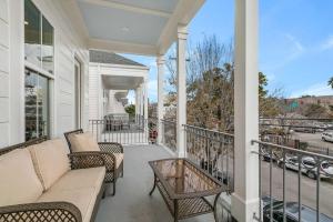 a porch with a couch and chairs on a balcony at Fabulous Cottages with City Views in New Orleans