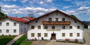 un gran edificio blanco con un cartel. en Pension und Ferienchalets Zum Lebzelter en Freyung