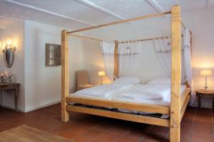 ein Schlafzimmer mit einem Himmelbett mit weißen Laken in der Unterkunft Spreewaldresort Seinerzeit in Schlepzig