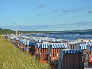 eine Reihe von Stühlen am Strand in der Nähe des Wassers in der Unterkunft Villa Strandidyll F 631 WG02 mit Meerblick in Binz