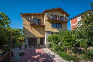 a house with a balcony and a driveway at Guest House Sun in Kranevo