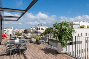 un patio con mesas y sillas en el balcón en master Shenkin en Tel Aviv