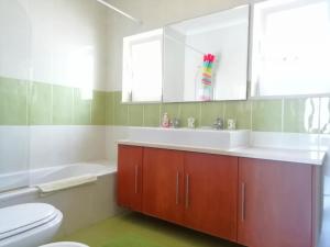 La salle de bains est pourvue d'un lavabo, d'une baignoire et de toilettes. dans l'établissement Casa Luminosa, à Carrapateira