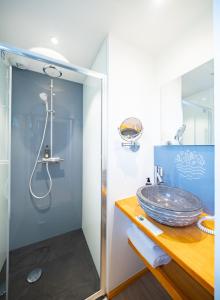 ein Bad mit einem Waschbecken und einer Dusche in der Unterkunft Le Hameau Des Sens in Phalsbourg