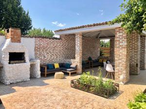 a patio with a brick wall and a fireplace at Casa Mediterana in 2 Mai