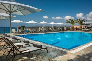 a large swimming pool with chairs and umbrellas at Antonia Hotel in Vlachata