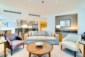 uma sala de estar com um sofá e duas cadeiras e uma mesa em Vida Downtown Residences no Dubai