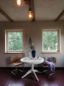 mesa y sillas en una habitación con 2 ventanas en Dobry Dom, en Sejny