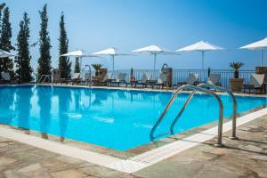 una gran piscina azul con sillas y sombrillas en Antonia Hotel en Vlachata