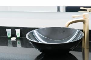 a black sink in a bathroom with a faucet at Glen Capri Inn and Suites - Burbank Universal in Glendale