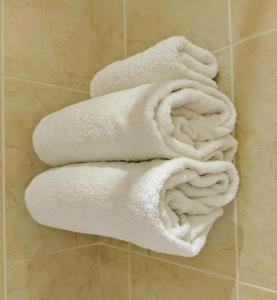 a pile of white towels on a wall in a bathroom at London Beach Country Hotel & Golf Club in Tenterden