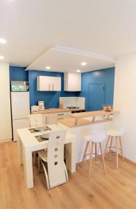 フレジュスにあるMas des hirondellesの青い壁のキッチン(テーブル、椅子付)
