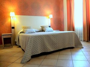 Un dormitorio con una cama grande con una manta blanca. en Villa Rosita, en Fiumicino