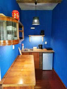 cocina con paredes azules y mesa de madera en Dobry Dom, en Sejny