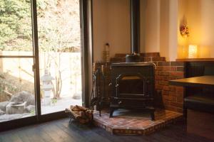 宮島にある宮島 女性限定のお宿 藤のやの窓付きの部屋のレンガ造りの暖炉