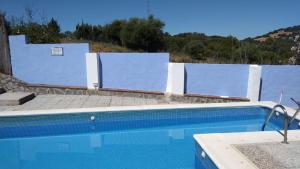 a swimming pool in front of a blue and white wall at El Garrotal in El Bosque