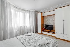 a white bedroom with a bed and a tv at RentWill CROCUS 246 in Krasnogorsk