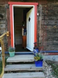 una puerta abierta de una casa con macetas en las escaleras en Dobry Dom, en Sejny