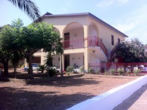 une maison avec un balcon et des arbres devant elle dans l'établissement Villa Augustea, à Alcamo