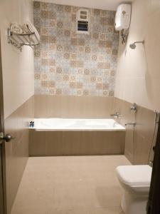 a bathroom with a bath tub and a toilet at Exotica Beach Retreats Diveagar in Diveagar